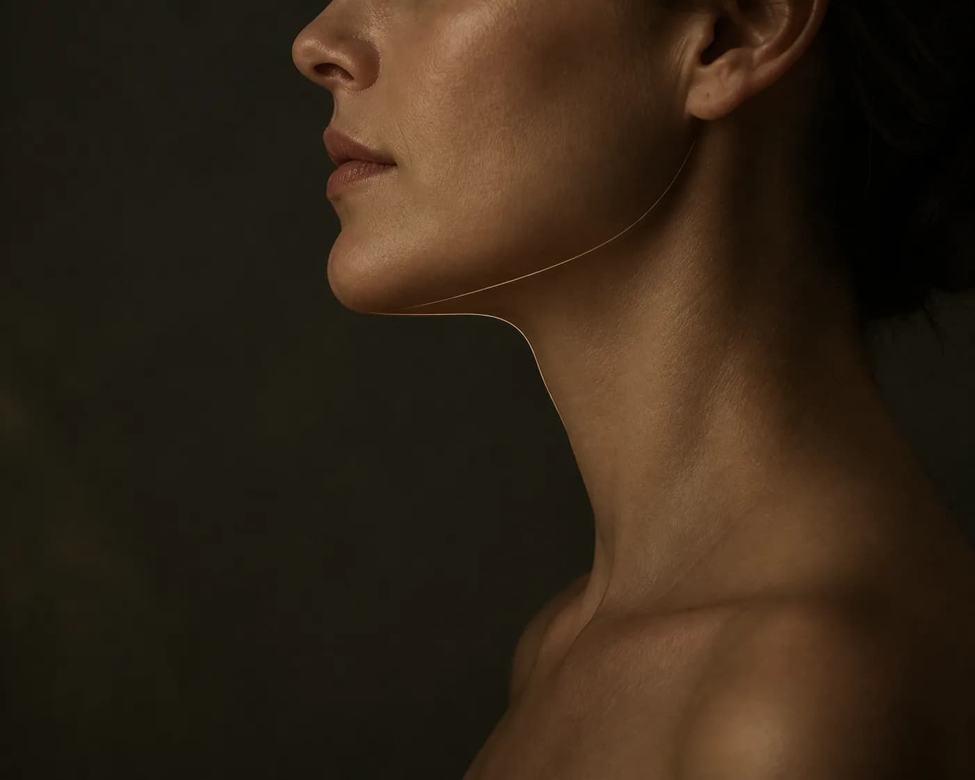 Alt yüz, çene hattı ve boyun arasındaki anatomik geçişi temsil eden koyu editorial profil görseli